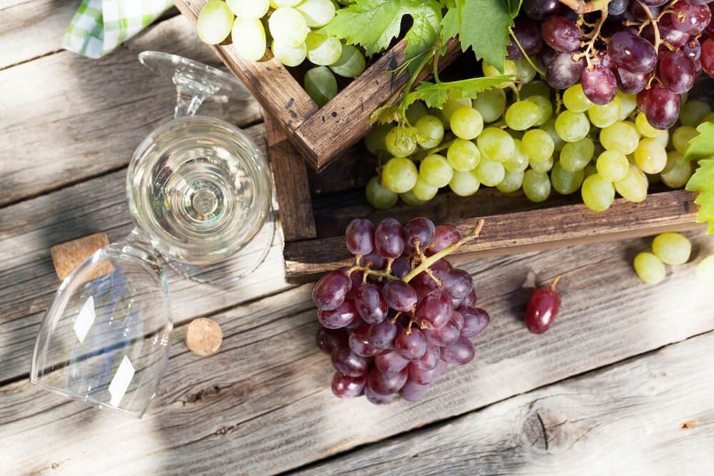 White wine and grape on wooden table
